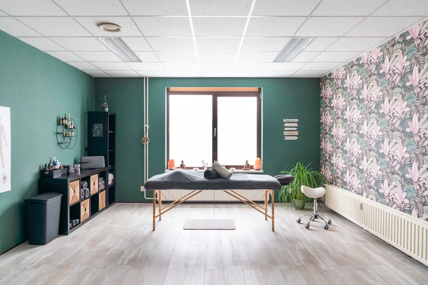 De behandelkamer van Balansil met massagetafel, planten en groene muren